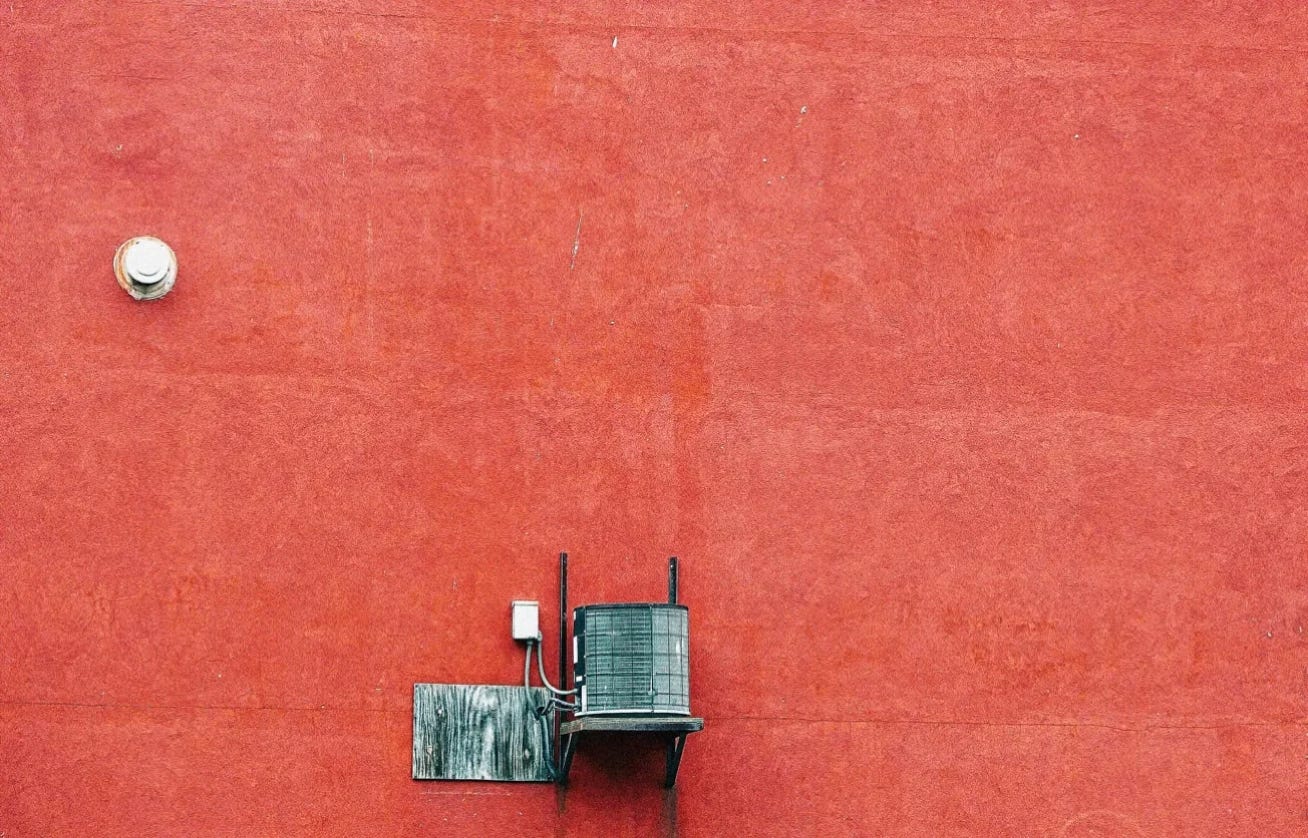 red wall of a house with a wooden water reservoir in Owego